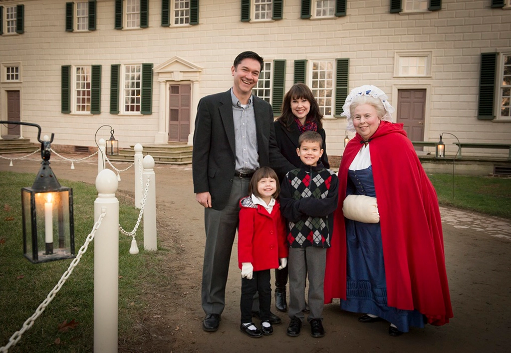 Besucher bei einer abendlichen Führung mit historischer Darstellerin vor dem Herrenhaus von Mount Vernon