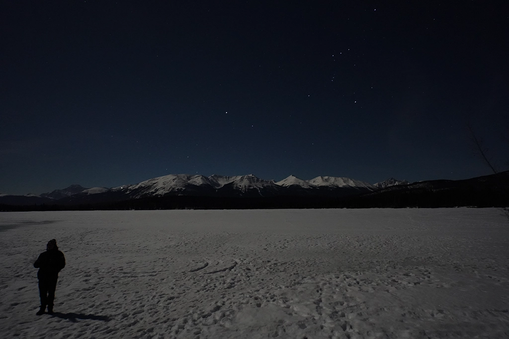 Sternenhimmel über dem verschneiten Pyramid Lake im Jasper Nationalpark
