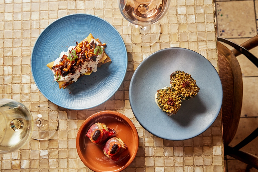 Kleine Gerichte aus einem Michelin-Restaurant in Nordamerika, angerichtet auf farbigen Tellern mit Weinbegleitung