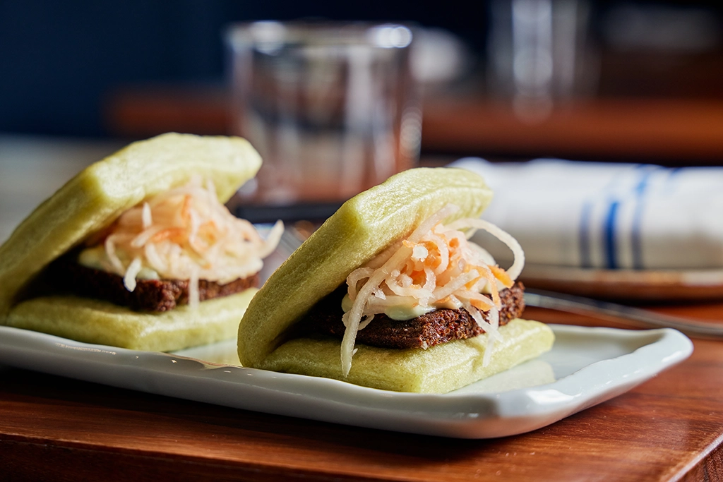 Zwei gefüllte Bao-Brötchen als Gericht aus einem Michelin-Restaurant in Nordamerika auf einem weißen Teller