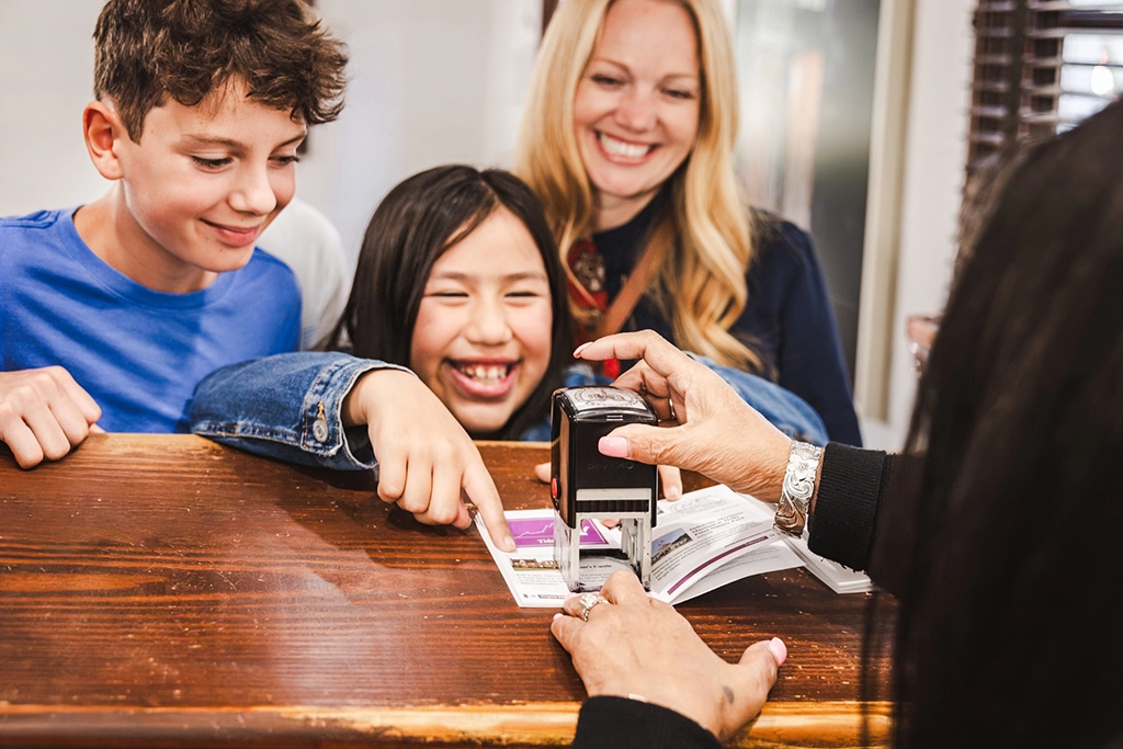 Kinder lassen ihren Virginia 250 Passport an einer historischen Stätte in Virginia abstempeln