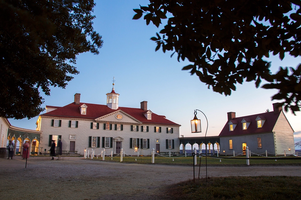 Abendansicht des Herrenhauses von Mount Vernon mit beleuchteten Fenstern und historischer Architektur