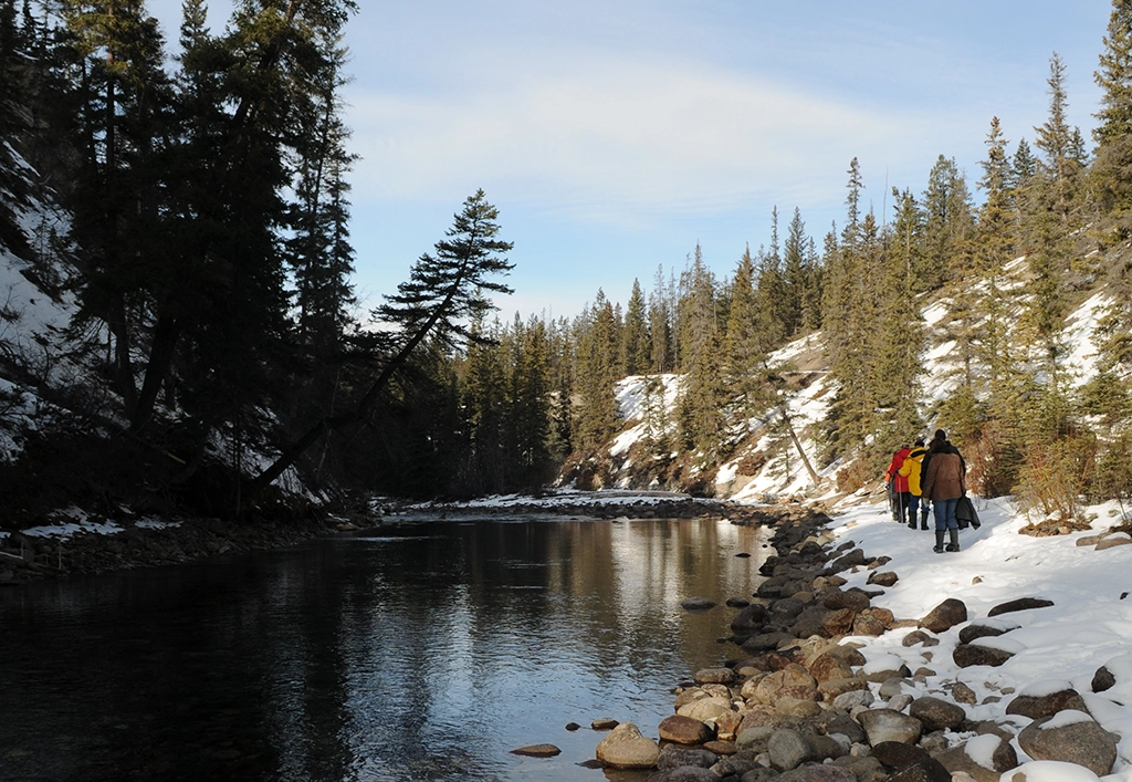 Winterwanderung entlang eines verschneiten Flussufers bei Jasper, Alberta