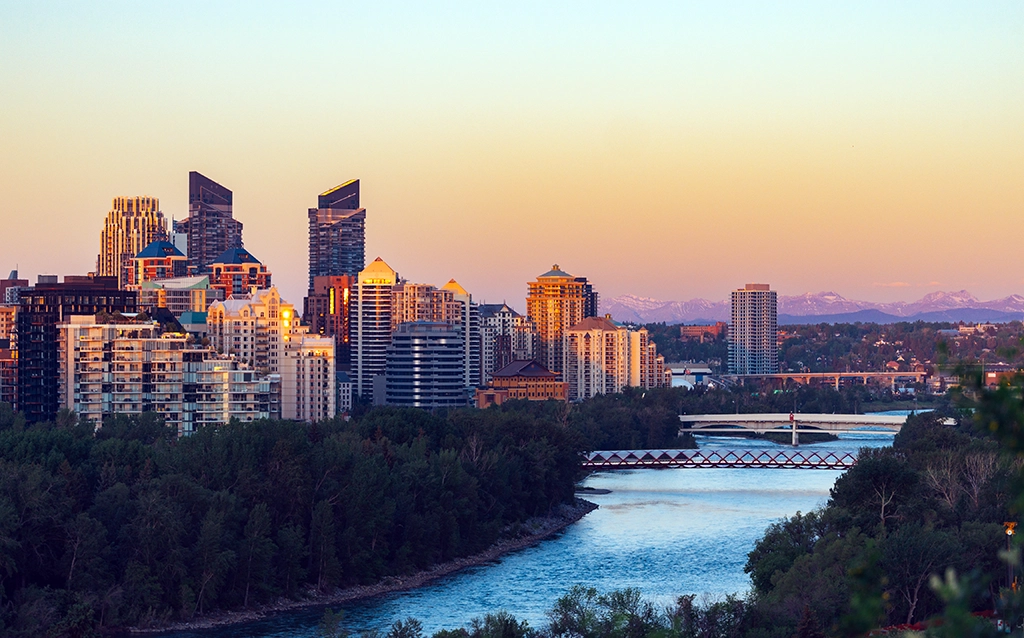 Skyline von Calgary mit Hochhäusern am Bow River bei Abendlicht
