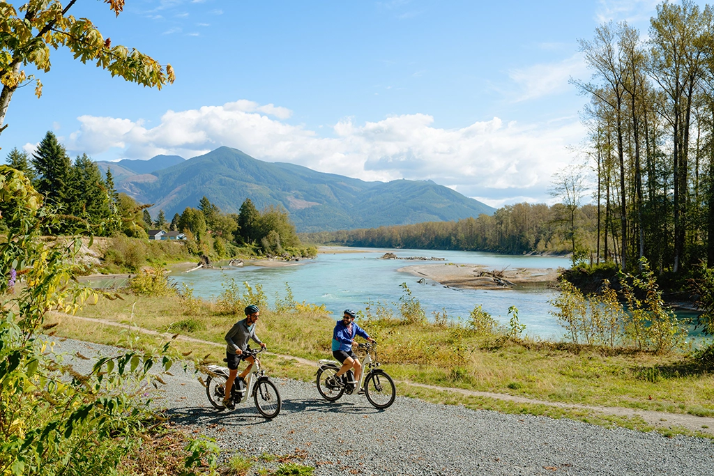 Zwei Radfahrer auf dem Cascade Trail entlang eines Flusses in Washington State.