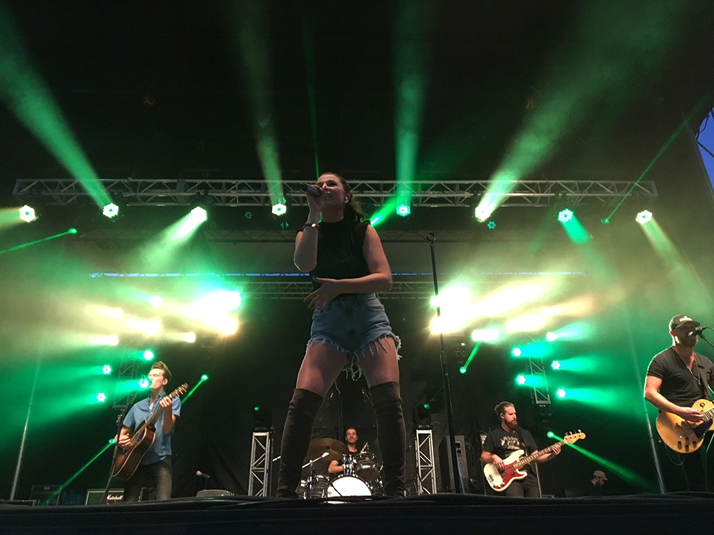 Sängerin mit Band auf Festivalbühne in Saskatchewan mit grüner Bühnenbeleuchtung