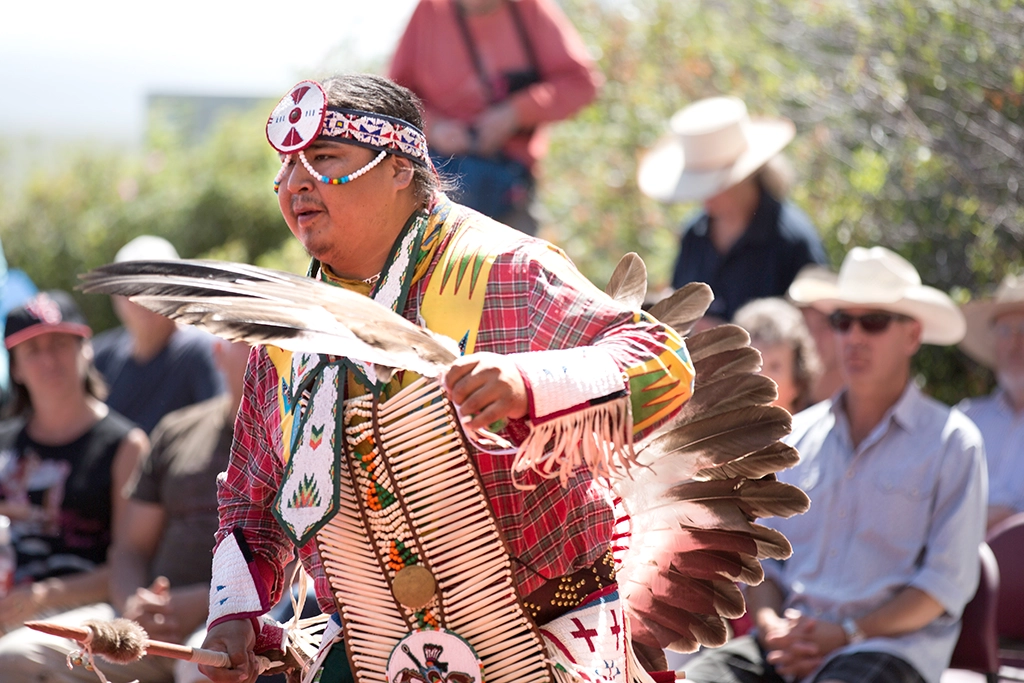 Indigener Tänzer in traditioneller Kleidung bei Head-Smashed-In Buffalo Jump in Alberta.
