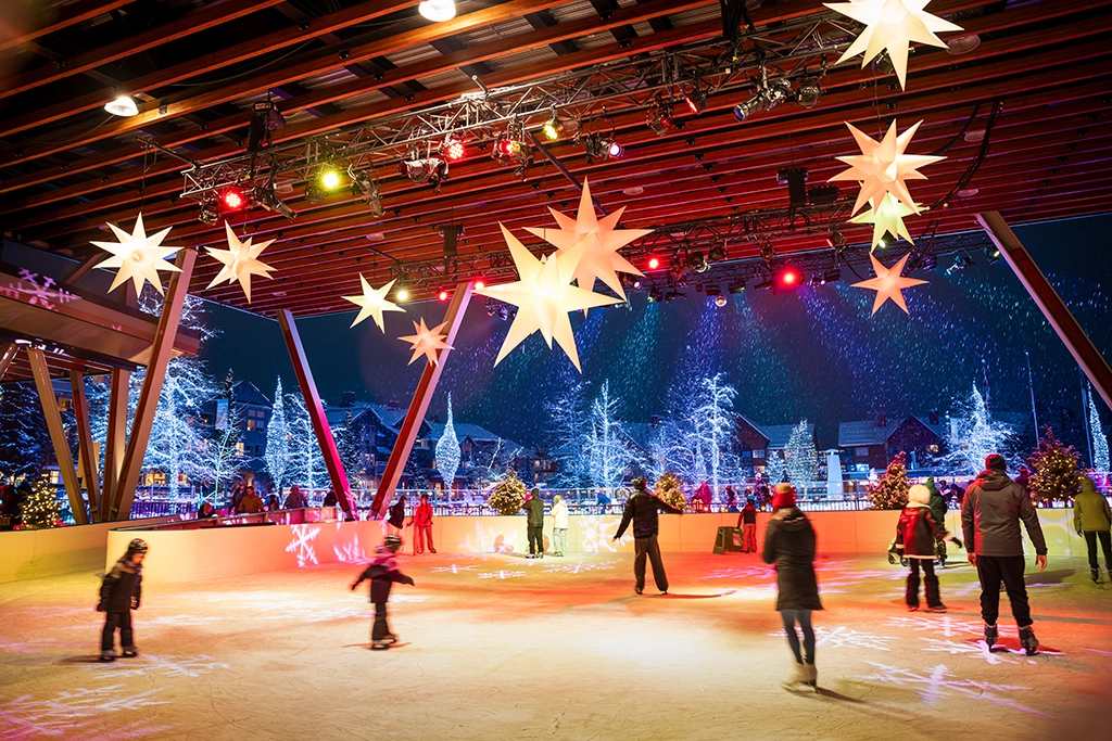 Eisbahn an der Olympic Plaza in Whistler bei Nacht mit beleuchteten Sternen und Winterszenerie.