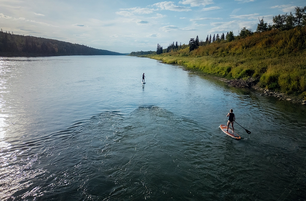 Zwei Personen beim Stand-up-Paddling auf dem North Saskatchewan River in Alberta.