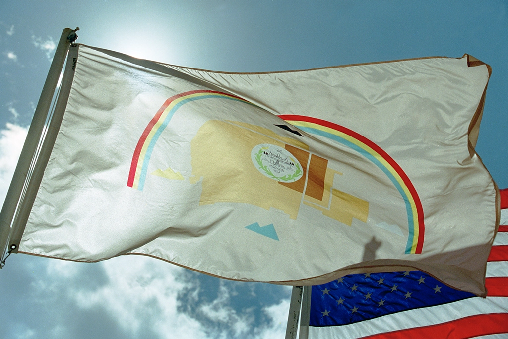 Flagge der Navajo Nation weht im Wind vor blauem Himmel in Arizona.