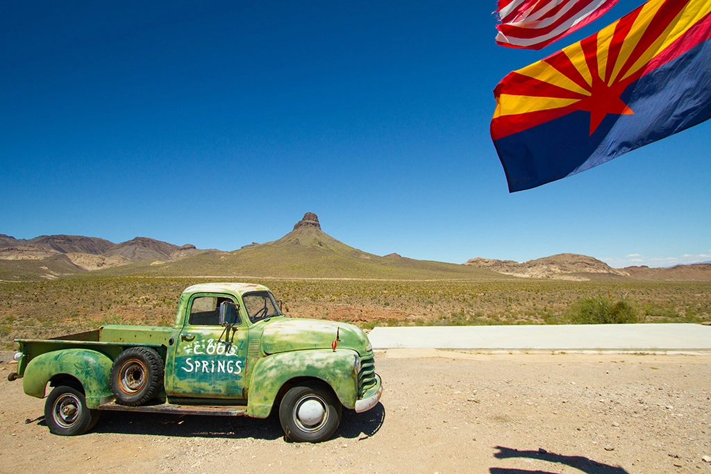 Alter Pickup-Truck an der historischen Route 66 bei Oatman in Arizona mit Arizona-Flagge.