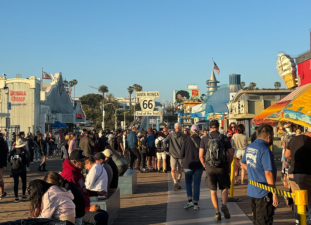 Menschen am Santa Monica Pier vor dem Route-66-End-of-the-Trail-Schild.