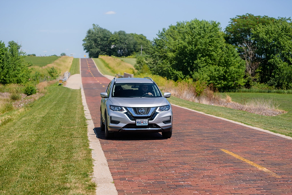 Auto fährt über den historischen Brick Road Abschnitt der Route 66 bei Auburn in Illinois.
