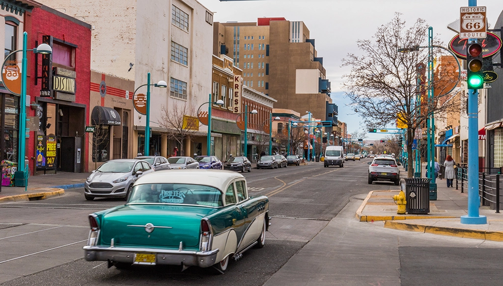 Historischer Route-66-Abschnitt in Downtown Albuquerque mit klassischem Oldtimer auf Central Avenue.