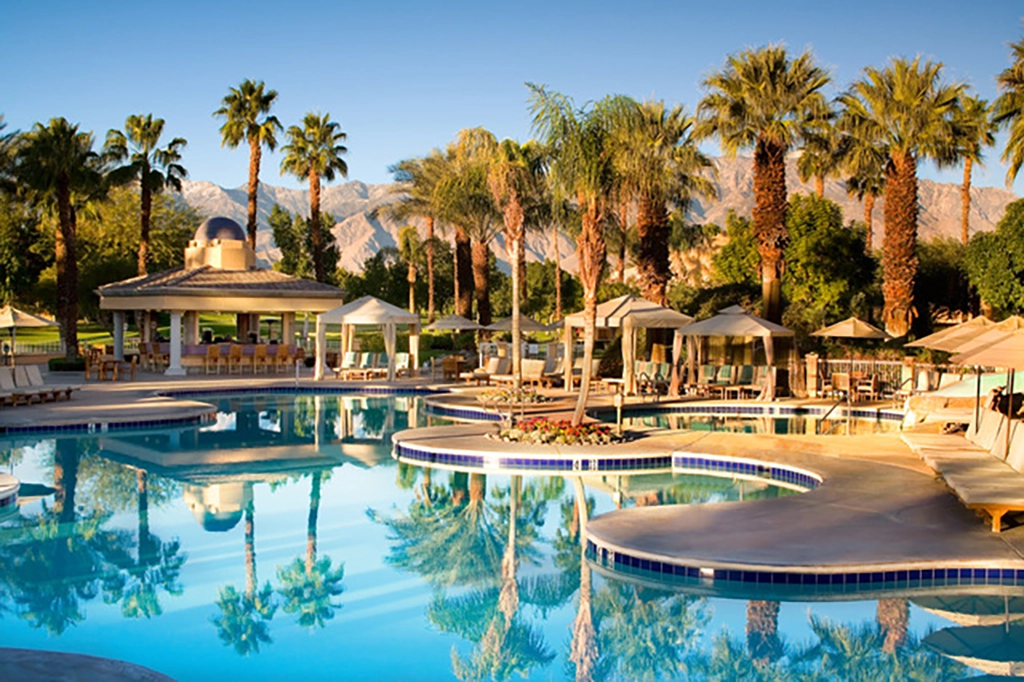 Poolanlage mit Palmen und Bergkulisse in Palm Springs bei Sonnenschein