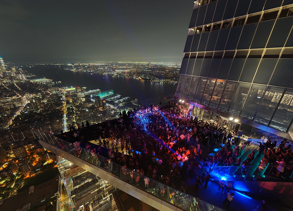 Menschenmenge auf Rooftop-Party mit Blick auf Manhattan bei Nacht