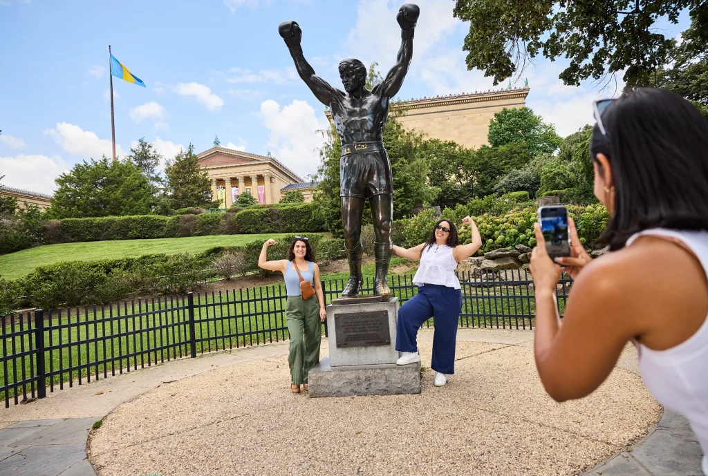Rocky-Statue vor dem Philadelphia Museum of Art mit posierenden Besuchern.