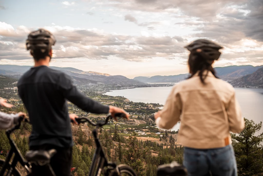 Radfahrer blicken auf Okanagan Lake und hügelige Landschaft bei Naramata