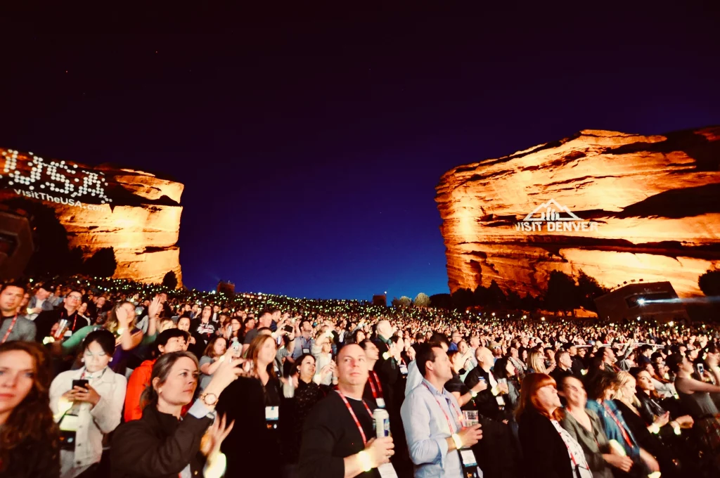Publikum bei einer Abendveranstaltung im beleuchteten Red Rocks Amphitheatre in Colorado.