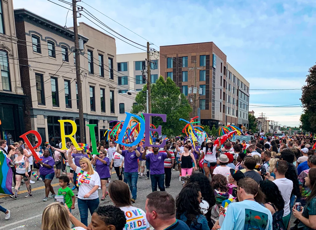 Teilnehmer der Kentuckiana Pride Parade mit bunten Pride-Buchstaben in Louisville.