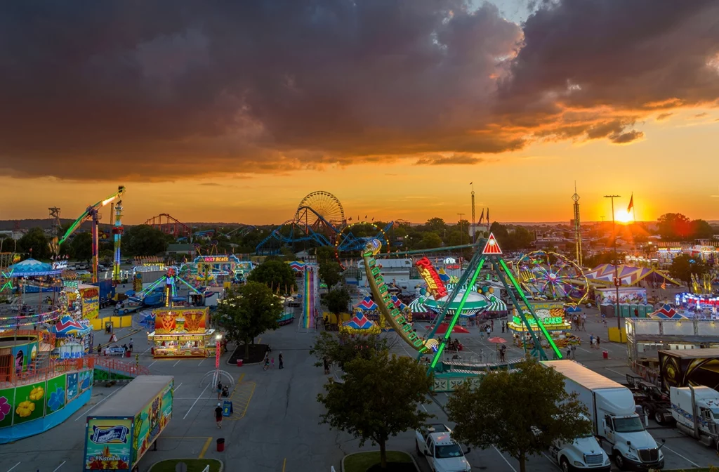 Beleuchtete Fahrgeschäfte auf der Kentucky State Fair in Louisville bei Sonnenuntergang.