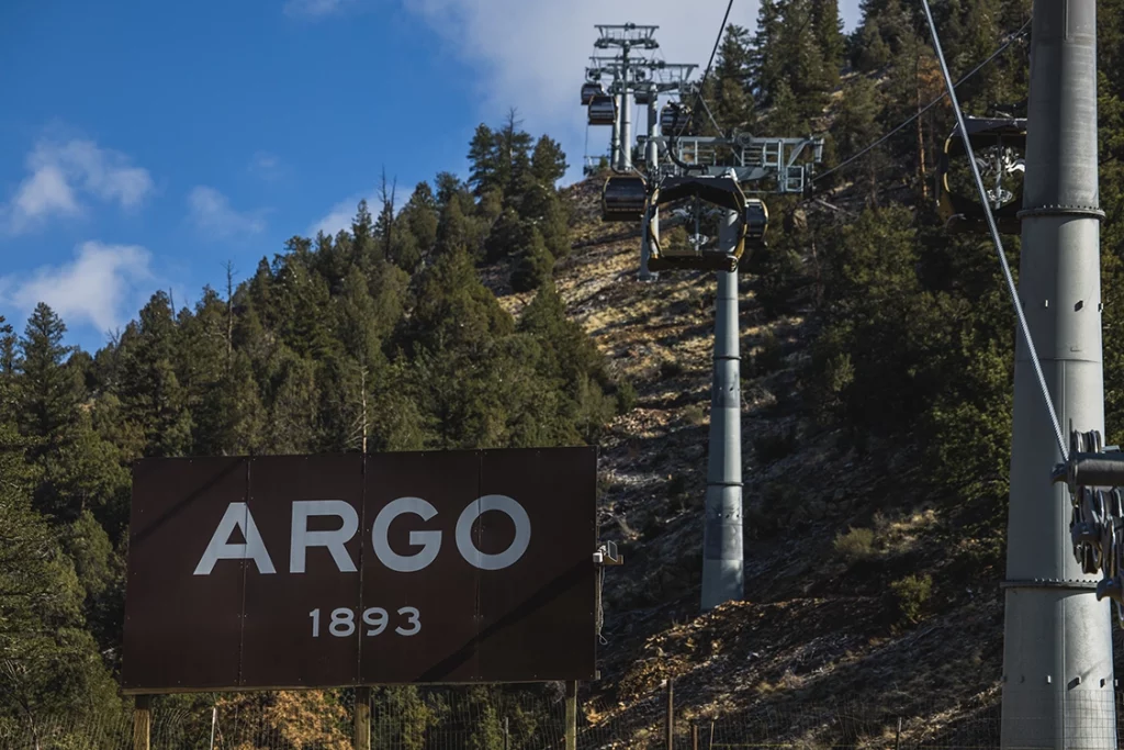 Talstation der Mighty Argo Gondelbahn in Idaho Springs vor bewaldeten Berghängen in Colorado.