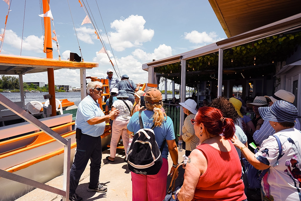 Besucher gehen an den Sponge Docks in Tarpon Springs an Bord eines Ausflugsboots der St. Nicholas Boat Line.
