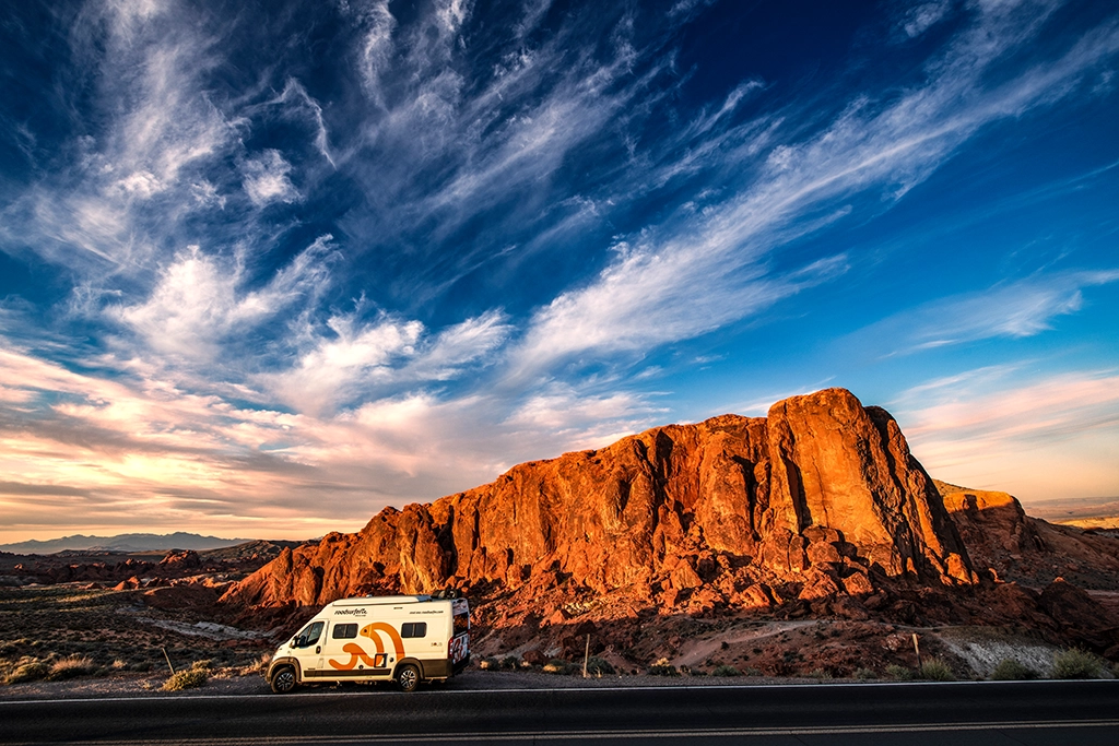 Wohnmobil im Abendlicht vor roten Sandsteinfelsen im Valley of Fire State Park in Nevada.