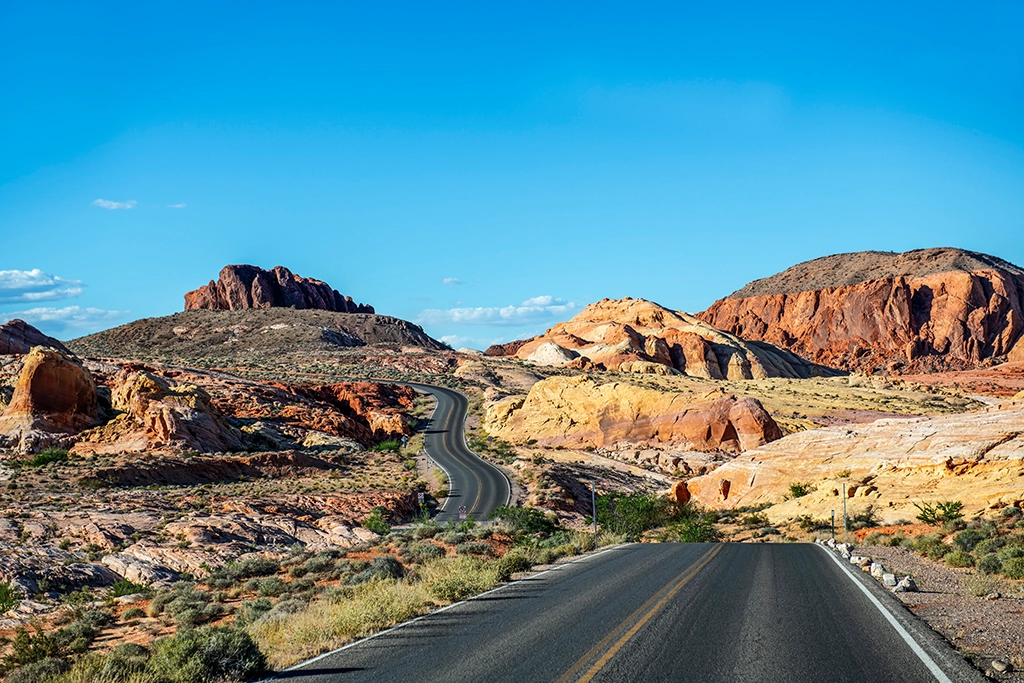 Einsame Straße durch farbige Felslandschaft in Nevada.