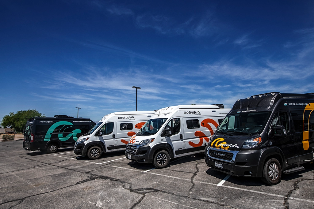 Mehrere Roadsurfer-Wohnmobile auf einem Parkplatz in den USA.