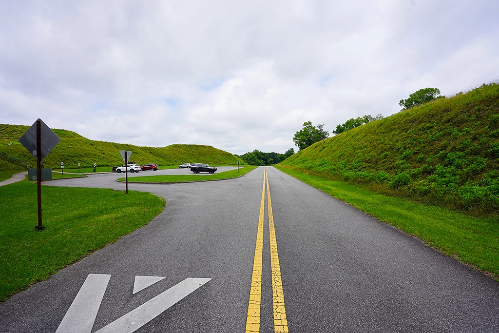 Straße führt zwischen den monumentalen Erdhügeln des Ocmulgee Mounds National Historical Park hindurch.