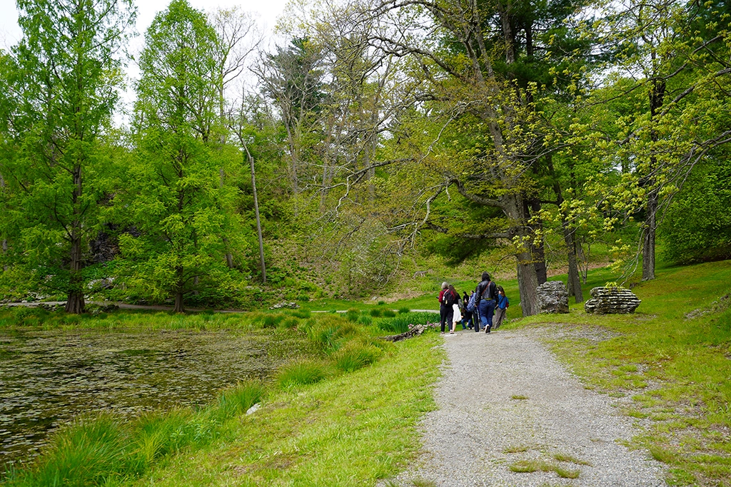 Besucher spazieren auf einem Weg entlang des Tyrrel Lake im Innisfree Garden im Hudson Valley.