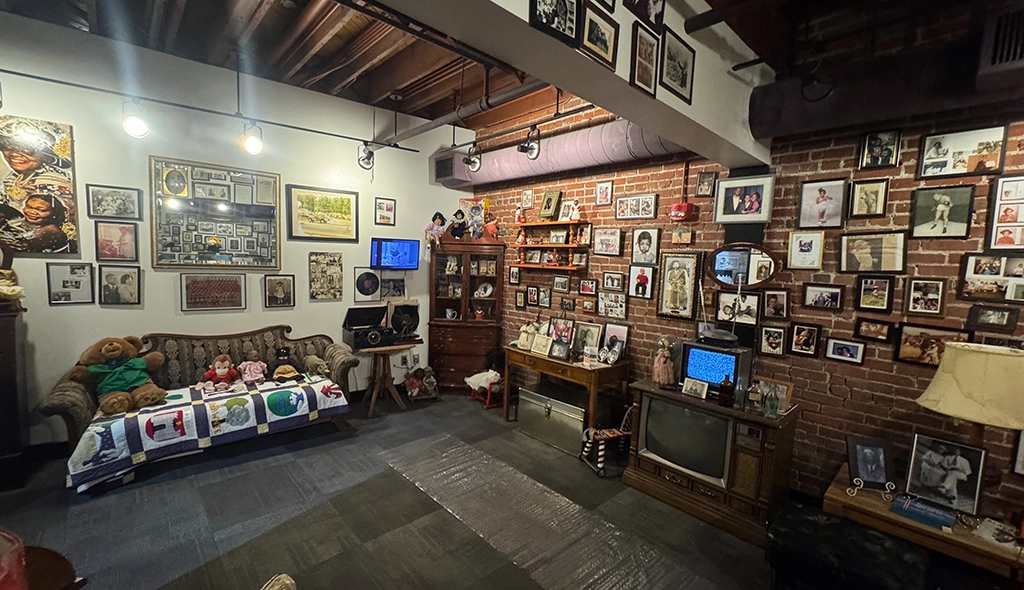 Nachgestelltes afroamerikanisches Wohnzimmer mit Familienfotos, alten Fernsehern und Erinnerungsstücken im Roots 101 Museum.