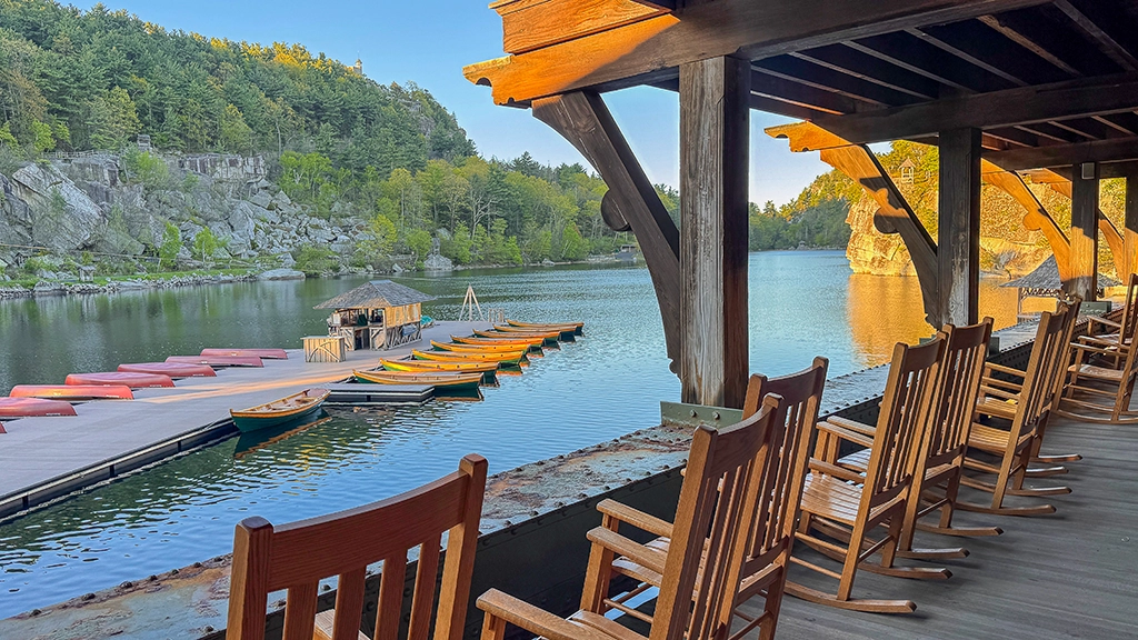 Veranda mit Schaukelstühlen und Blick auf Lake Mohonk und die Bootsanleger des Mohonk Mountain House.