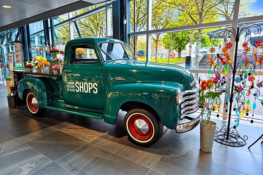 Grüner Chevrolet 3100 Pickup mit farbenfrohen Glasobjekten im Corning Museum of Glass in Corning, New York.