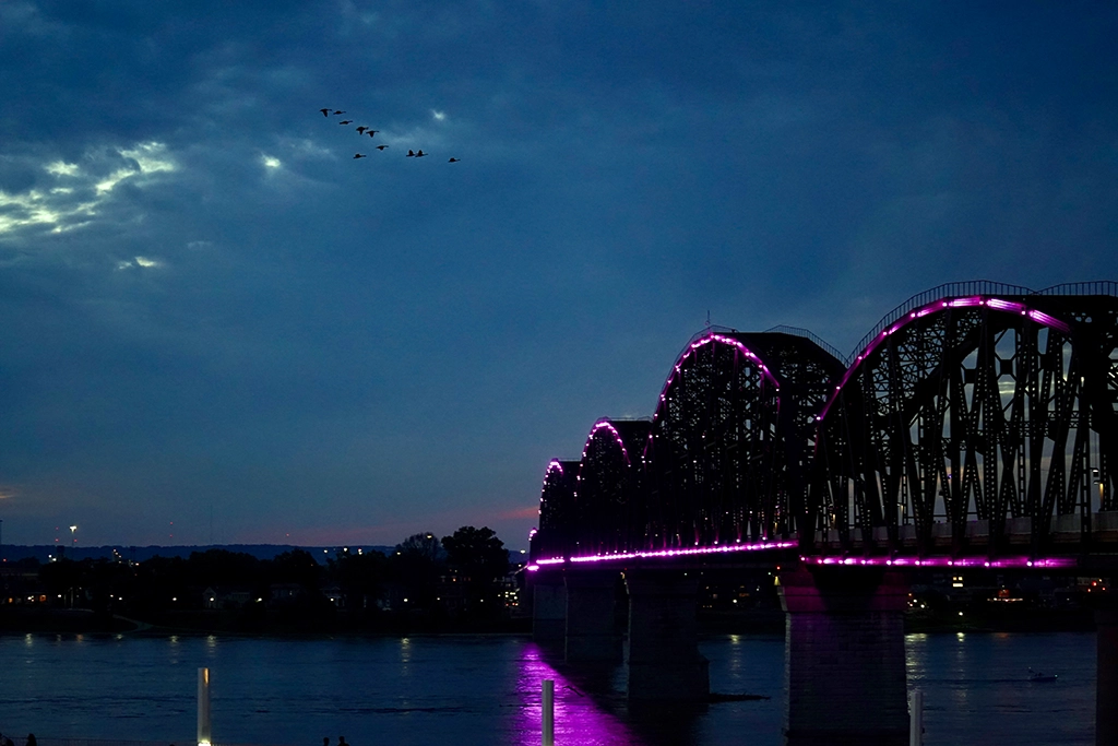 Beleuchtete Big Four Bridge über dem Ohio River bei Louisville in der Abenddämmerung.