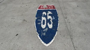 Abgenutztes Interstate-65-Schild als Straßenmarkierung auf dem Asphalt in den USA.