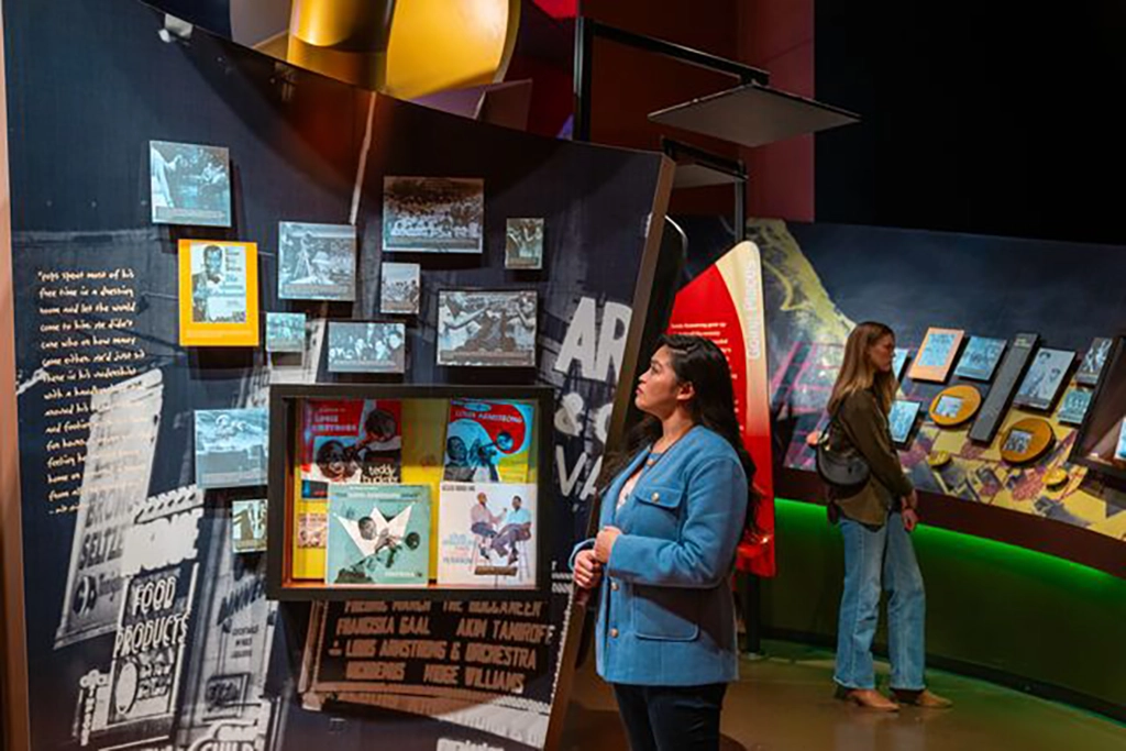 Besucherinnen erkunden eine Ausstellung über die Geschichte des amerikanischen Jazz im American Jazz Museum in Kansas City, Missouri.