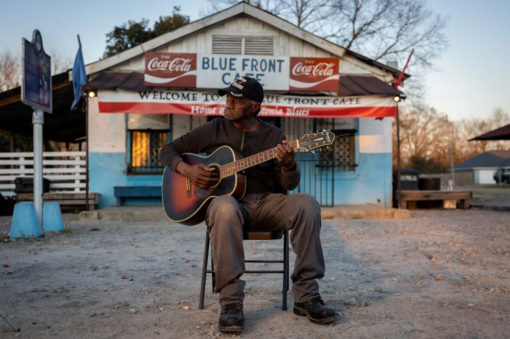 Bluesmusiker mit Akustikgitarre vor dem Blue Front Café in Bentonia, Mississippi, einem der bekanntesten Juke Joints der amerikanischen Südstaaten.