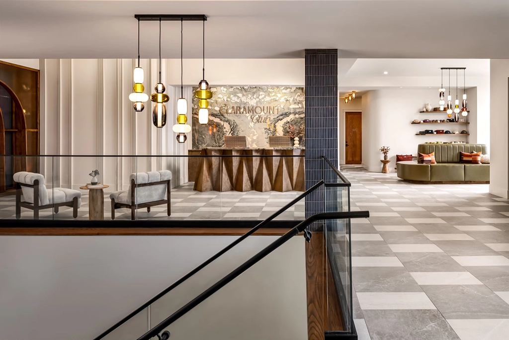 Moderne Lobby des Claramount Club in Picton mit eleganter Rezeption, Designerleuchten, Sitzbereichen und Natursteinboden