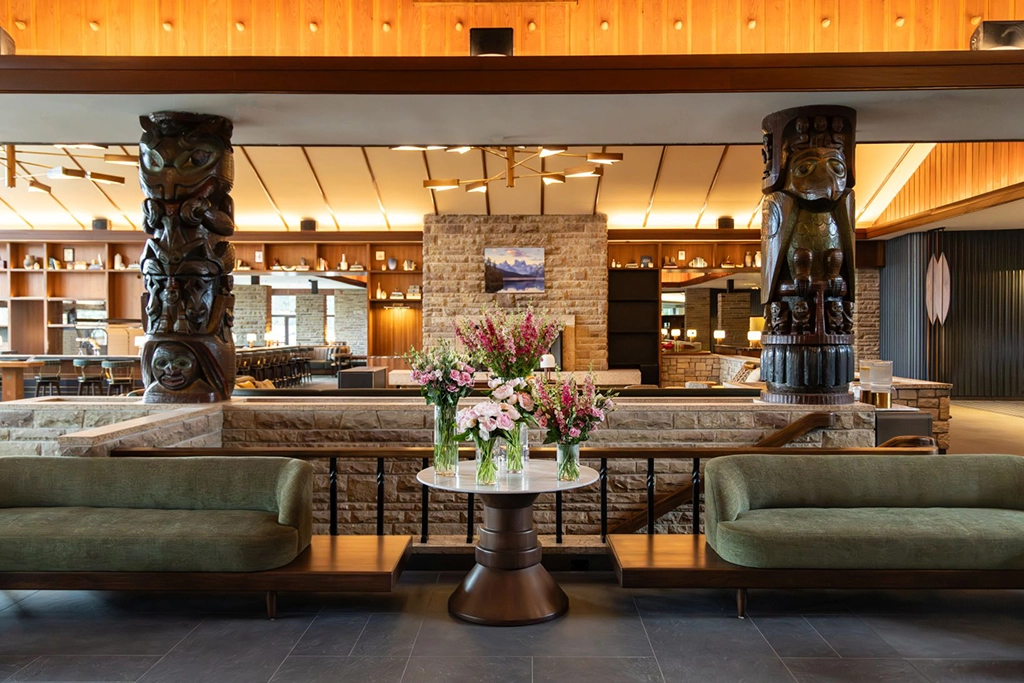 Modernisierte Lobby der Fairmont Jasper Park Lodge mit geschnitzten Holzsäulen, Natursteinwänden und gemütlichen Sitzbereichen im Jasper-Nationalpark