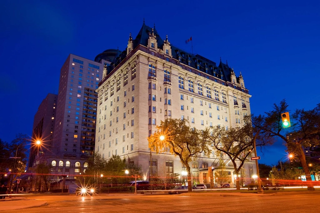 Beleuchtete Fassade des Fort Garry Hotels in Winnipeg bei Einbruch der Dunkelheit mit markantem Château-Dach und französisch inspirierter Architektur