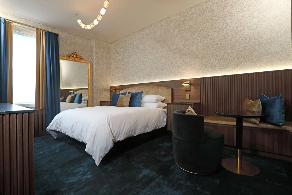 Modernisiertes Hotelzimmer mit Kingsize-Bett, eleganten Holzmöbeln und Sitzecke auf dem Vice Regal Floor des Fort Garry Hotels in Winnipeg, Manitoba