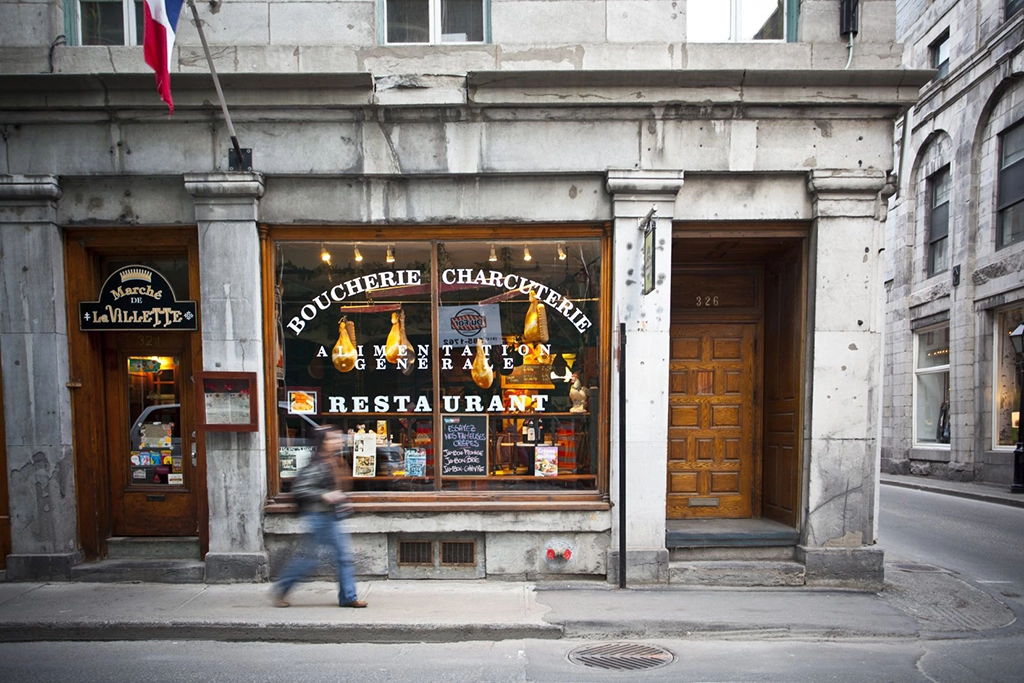 Traditionelle Steinfassade mit Restaurant und Feinkostgeschäft in der Altstadt Vieux-Montréal in Québec