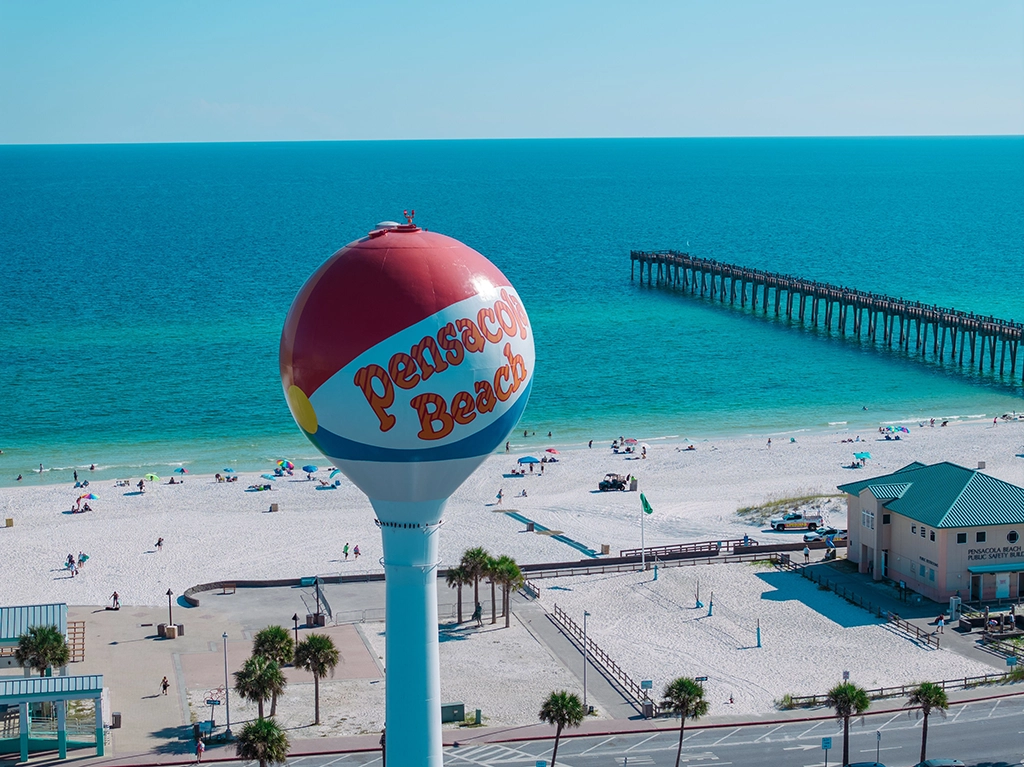 Pensacola Beach mit weißem Sand, türkisfarbenem Meer und Wasserturm in Florida