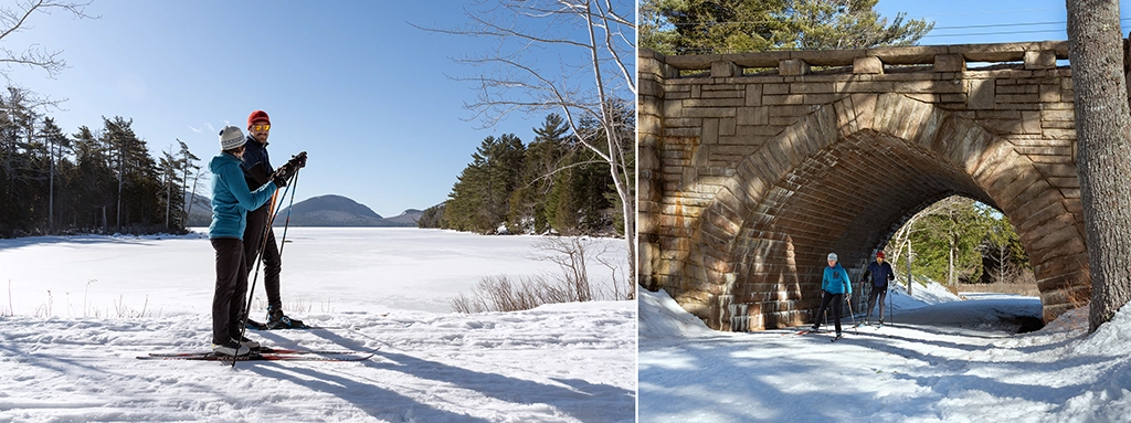 Zwei Langläufer auf verschneiten Wegen im Acadia National Park in Maine, mit zugefrorenem See und steinerner Brücke